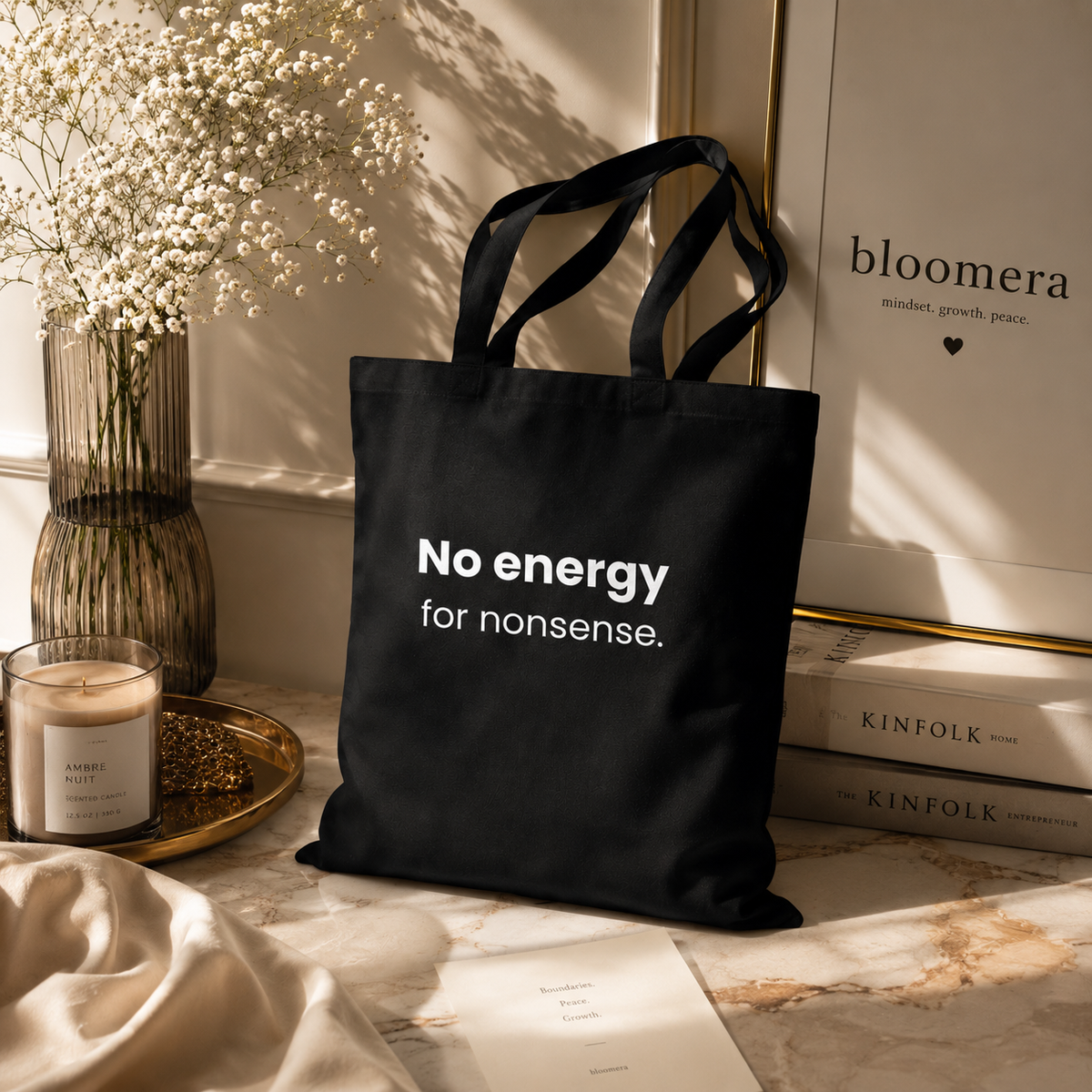 Black canvas tote bag with "No energy for nonsense" slogan in a minimalist styled interior